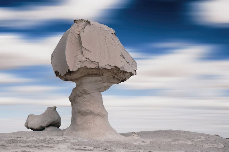 Il celebre fungo di gesso con la gallina accanto sotto nuvole mosse nel Deserto Bianco