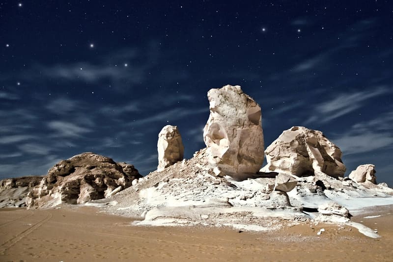 Formazioni di gesso illuminate dalla luna sotto un cielo stellato nel Deserto Bianco