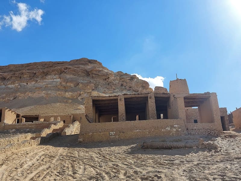 Edifici tradizionali in argilla ai piedi della montagna rocciosa del Gebel Dakrour a Siwa